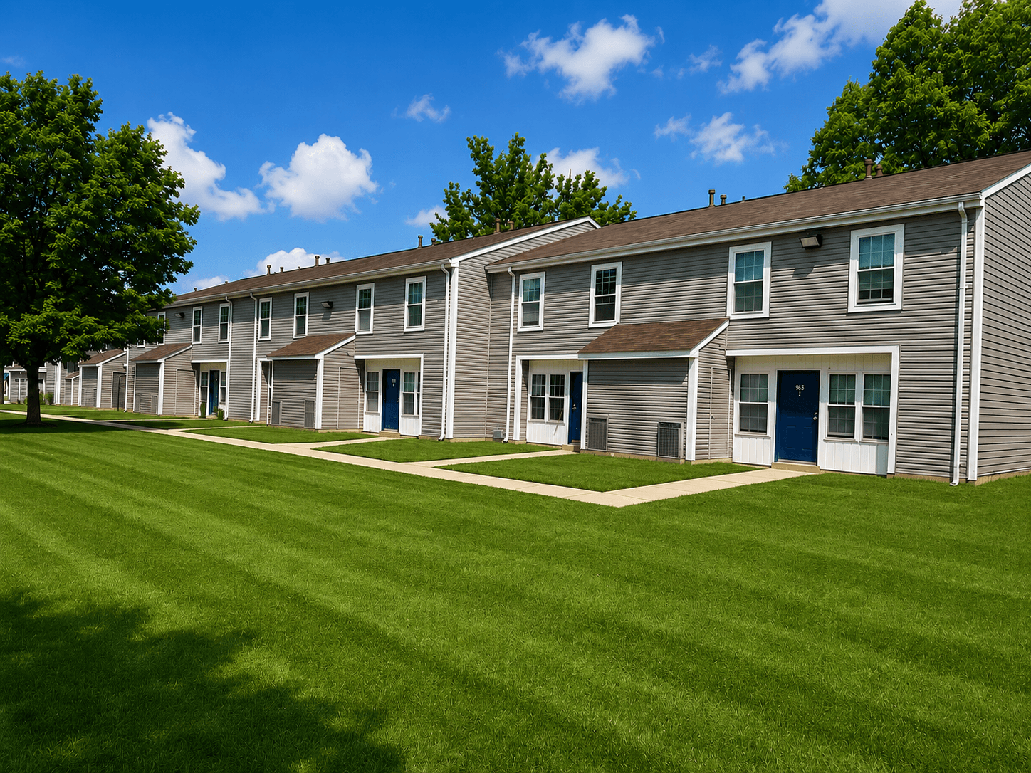 A row of houses with green lawns in front.
